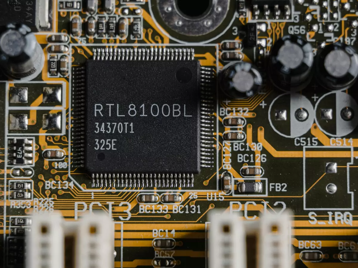 Close-up of a smartphone motherboard with various components, including a large chip labeled 'RTL8100BL' and connectors.